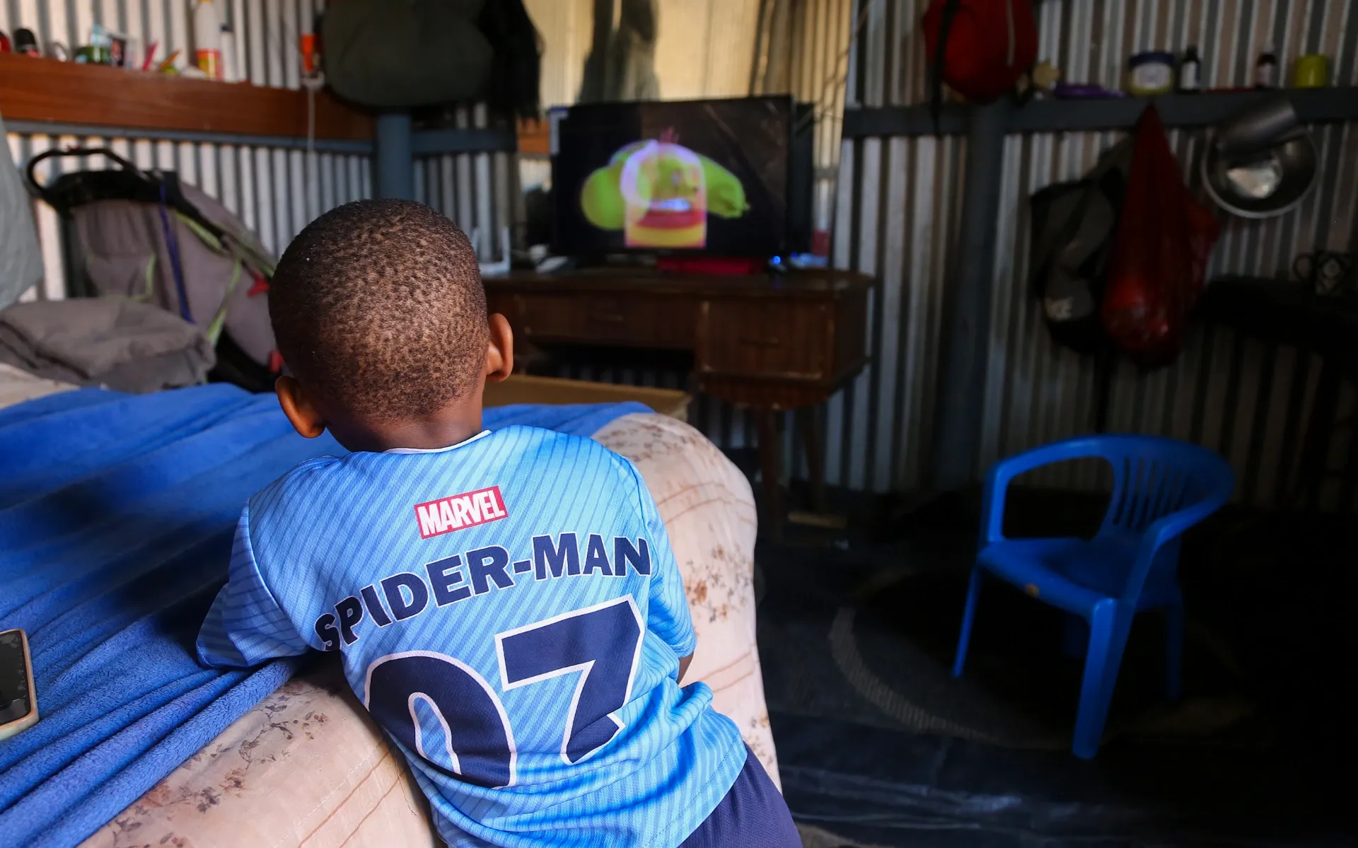 A young boy watches cartoons at his home in KuGompo City, East London, Eastern Cape, South Africa, on 27 August 2026. The boy is unable to walk and spends a lot of his time watching televison. His mother, *Zoe, gave birth to him at Frere Hospital after enduring two weeks of labour before hospital staff admitted her. Photograph: Mark Andrews/SA|AJP
